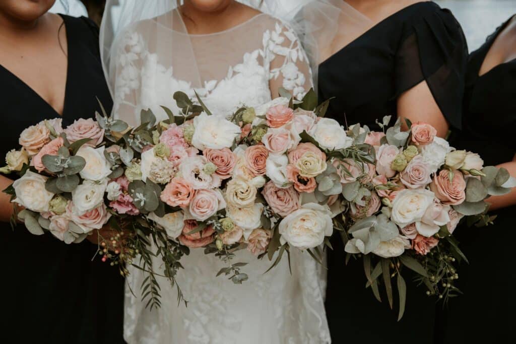 Bride With Bridesmaid Holding Flower Bouquet