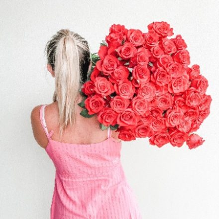 Woman Carrying Large Bouquet Of Red Roses — Florist in Birtinya, QLD