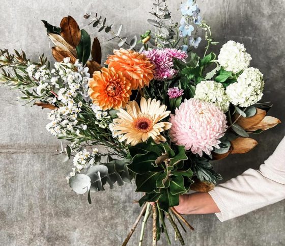 Woman Holding Flowers Of Different Kinds